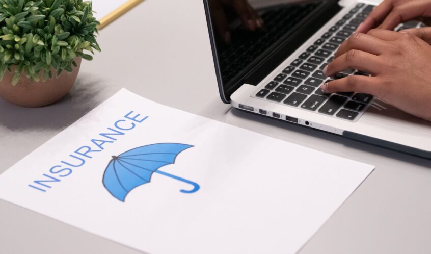 Free A Paper beside a Person Typing on a Laptop Stock Photo