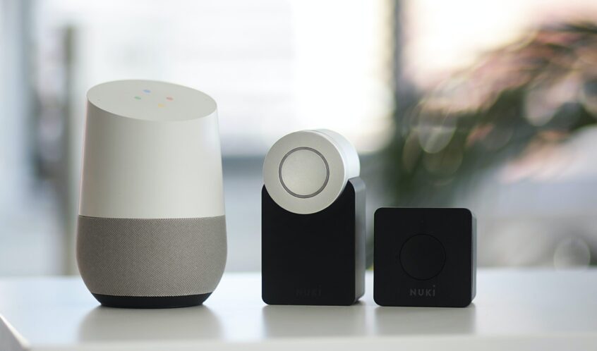 white and gray Google smart speaker and two black speakers
