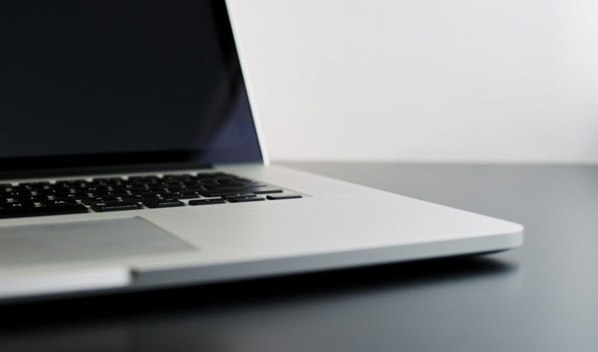 silver laptop computer on black table